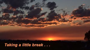 Image of an orange sunset sky with clouds with the words "Taking a Little Break" at the bottom.